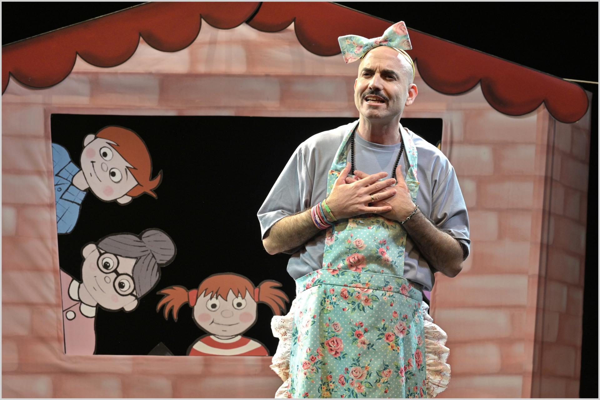 צילום של השחקן על רקע תפאורה של בית עם ילדים מצויירים